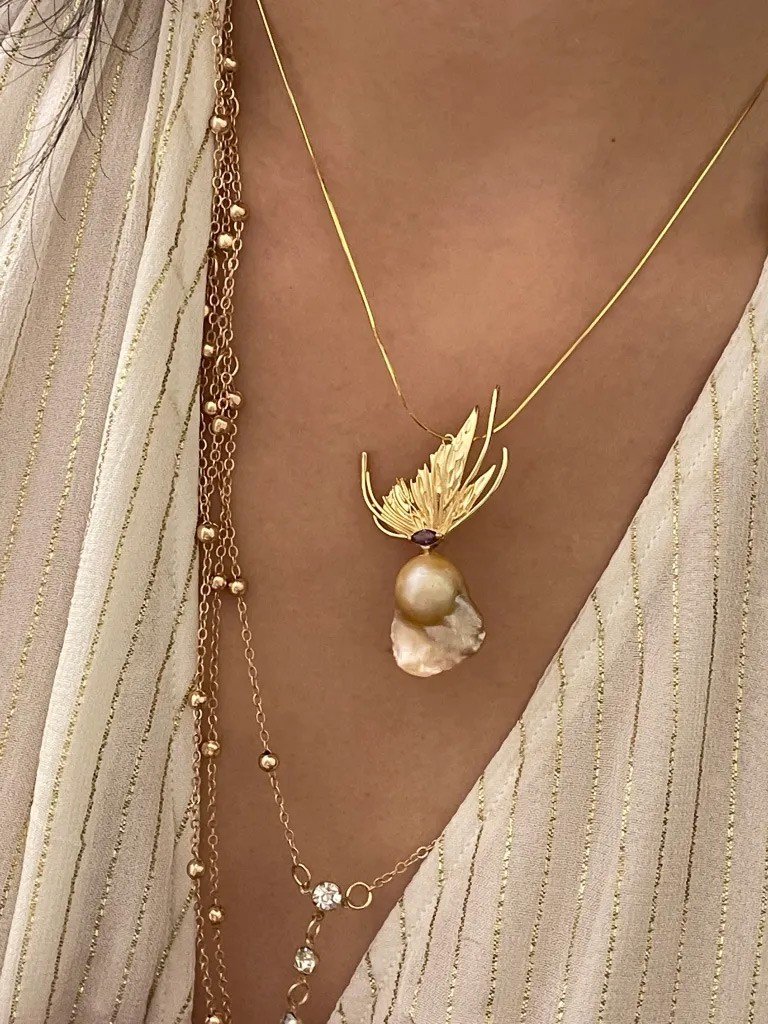 Close-up of pearls being crafted into jewelry with fine pliers